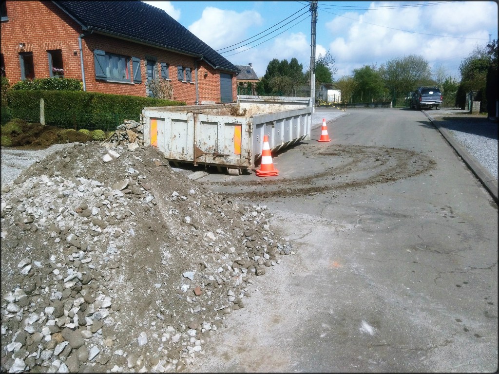Un conteneur de camion avec à côté un tas de gravas