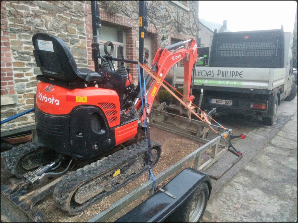 Camion avec remorque chargée d'une minipelle