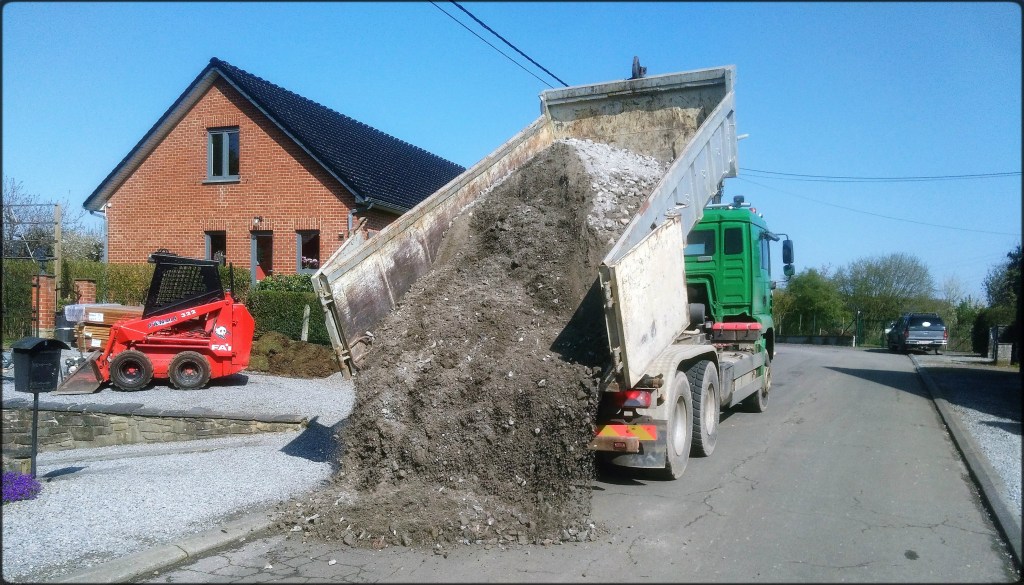 Un camion conteneur qui décharge des gravas